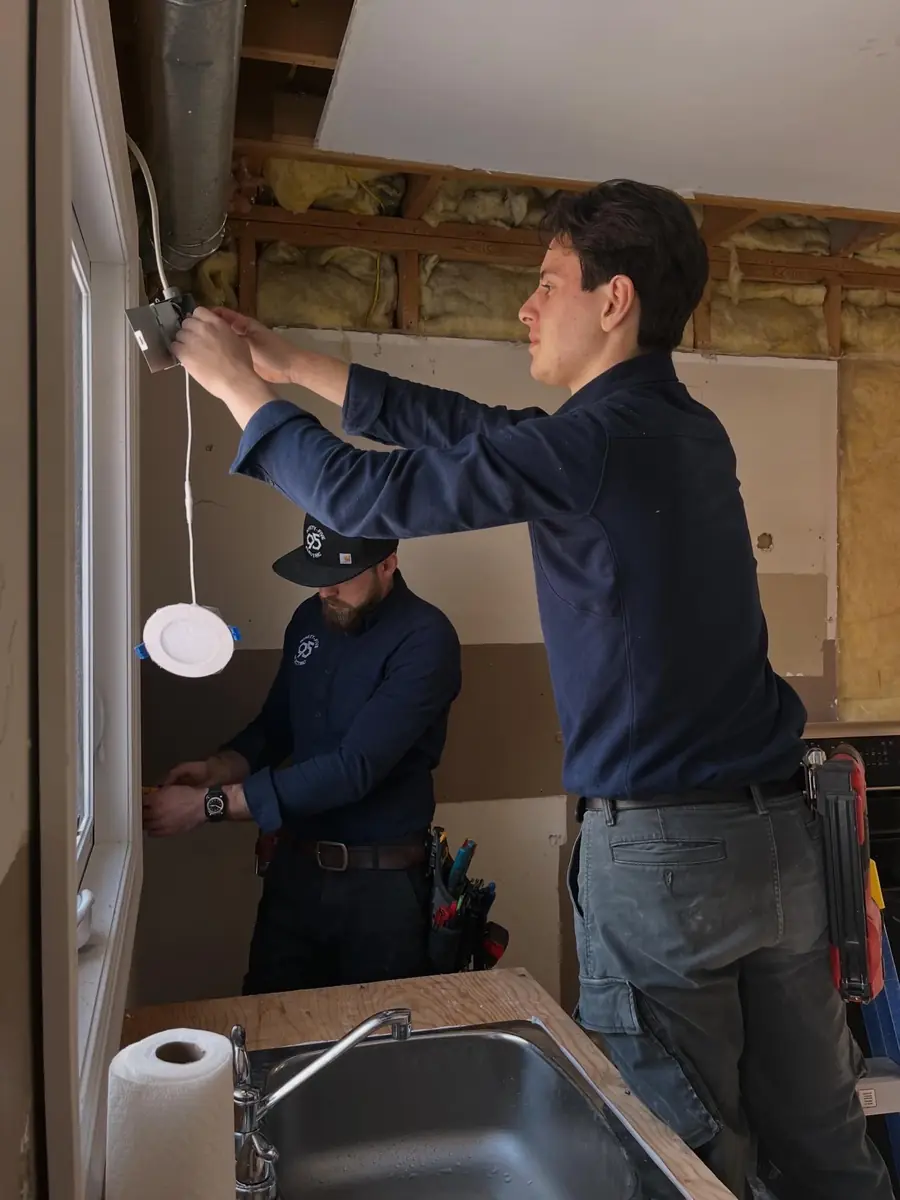 Marcello and Caleb troubleshooting electrical wiring together